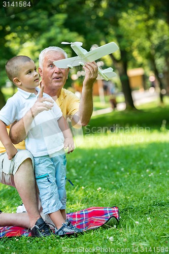 Image of grandfather and child have fun  in park