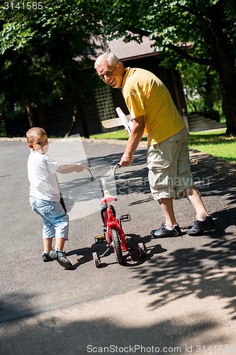 Image of grandfather and child have fun  in park