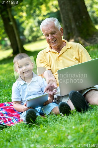 Image of grandfather and child using laptop