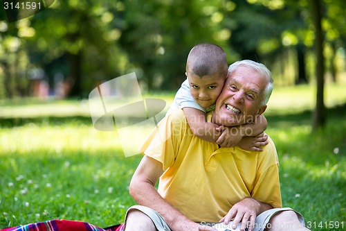 Image of grandfather and child have fun  in park