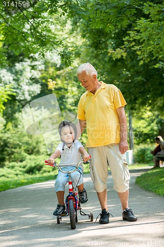 Image of grandfather and child have fun  in park