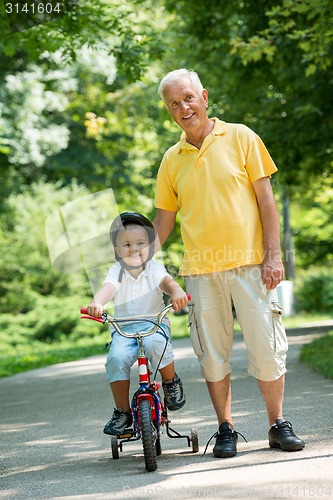 Image of grandfather and child have fun  in park