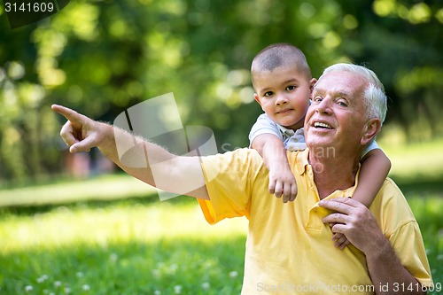 Image of grandfather and child have fun  in park