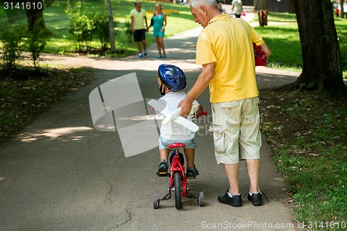 Image of grandfather and child have fun  in park