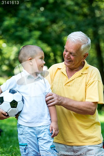 Image of grandfather and child have fun  in park