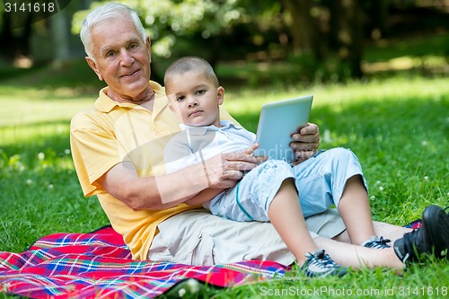 Image of grandfather and child using laptop