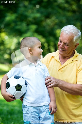 Image of grandfather and child have fun  in park