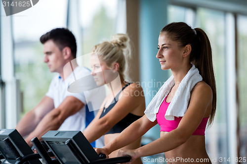 Image of friends  exercising on a treadmill at the bright modern gym