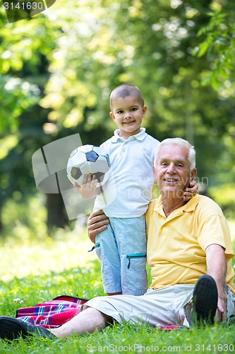 Image of grandfather and child have fun  in park