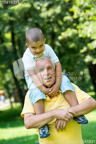 Image of grandfather and child have fun  in park