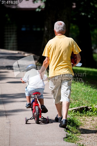 Image of grandfather and child have fun  in park