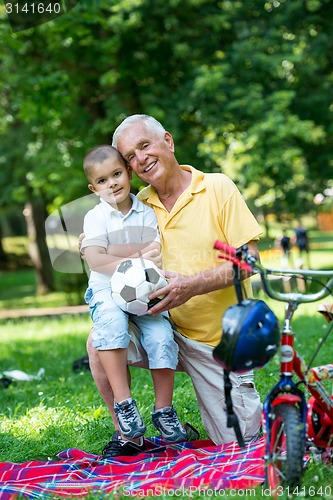 Image of grandfather and child have fun  in park