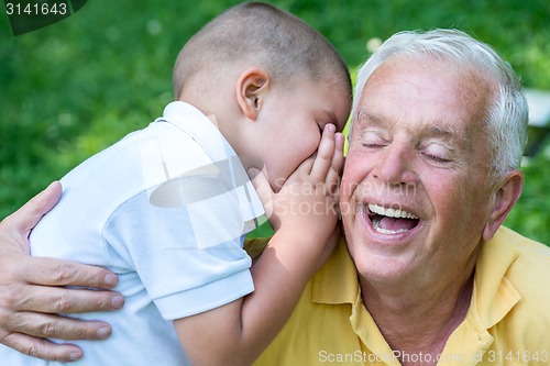 Image of grandfather and child have fun  in park