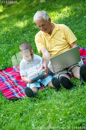 Image of grandfather and child using laptop