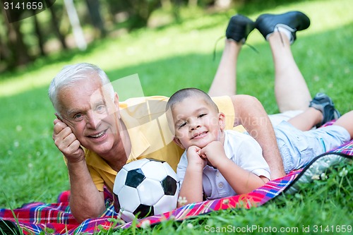 Image of grandfather and child have fun  in park