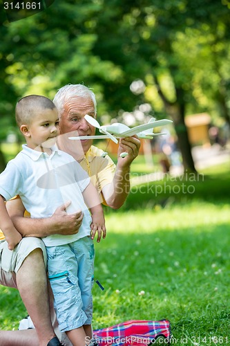 Image of grandfather and child have fun  in park