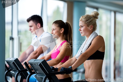 Image of friends  exercising on a treadmill at the bright modern gym