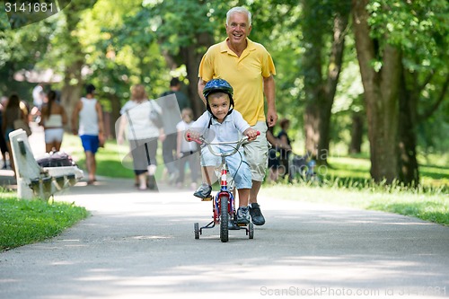Image of grandfather and child have fun  in park