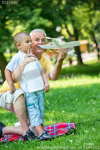 Image of grandfather and child have fun  in park