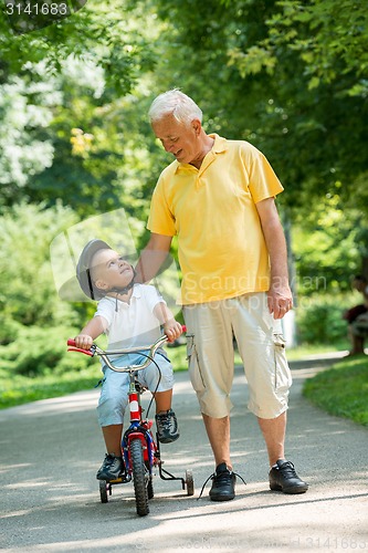 Image of grandfather and child have fun  in park