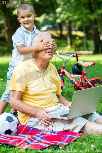 Image of grandfather and child using laptop