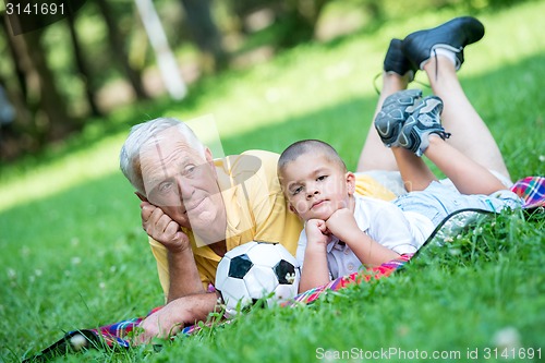 Image of grandfather and child have fun  in park