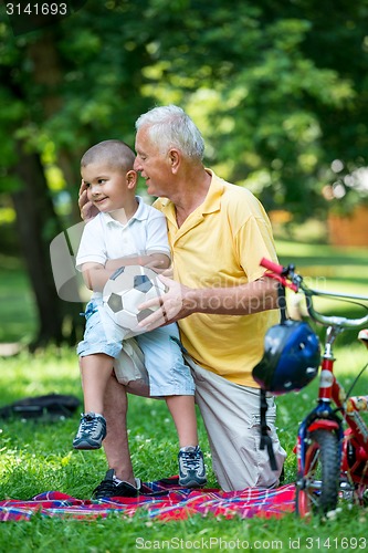 Image of grandfather and child have fun  in park