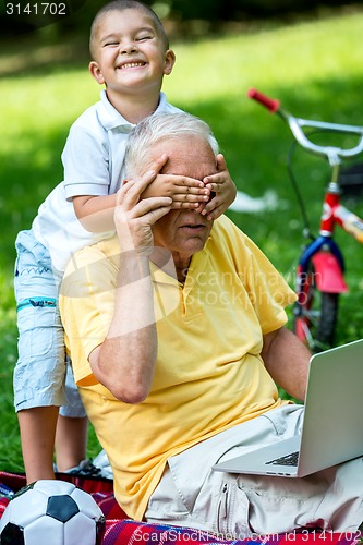 Image of grandfather and child have fun  in park