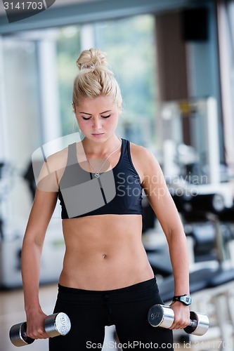 Image of lifting some weights and working on her biceps in a gym