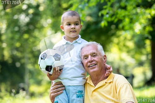 Image of grandfather and child have fun  in park