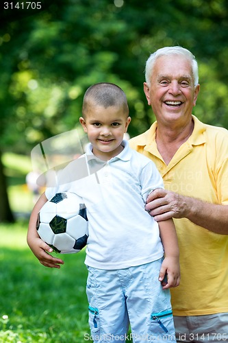 Image of grandfather and child have fun  in park