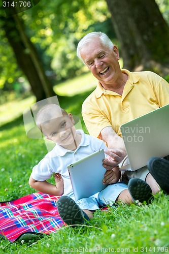 Image of grandfather and child using laptop