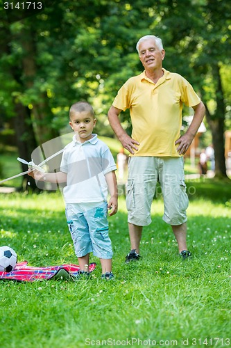 Image of grandfather and child have fun  in park