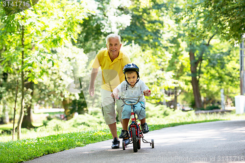 Image of grandfather and child have fun  in park