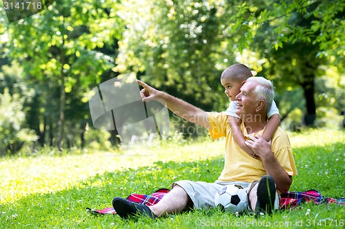 Image of grandfather and child have fun  in park