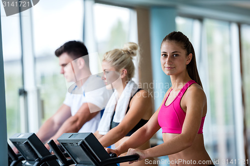 Image of friends  exercising on a treadmill at the bright modern gym