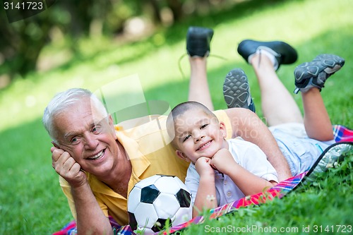 Image of grandfather and child have fun  in park