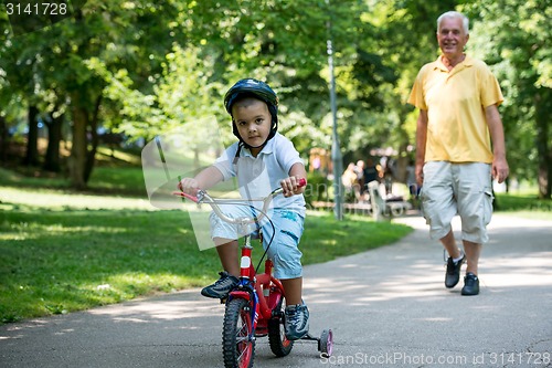 Image of grandfather and child have fun  in park