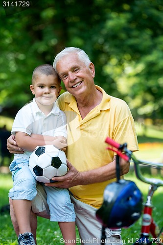 Image of grandfather and child have fun  in park