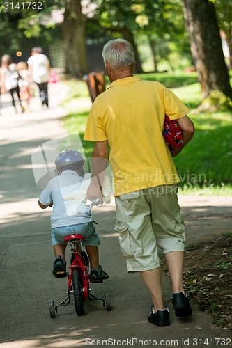 Image of grandfather and child have fun  in park