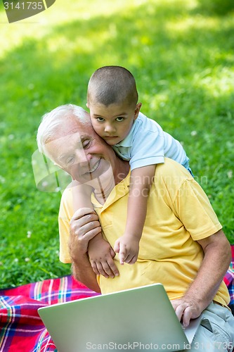 Image of grandfather and child using laptop