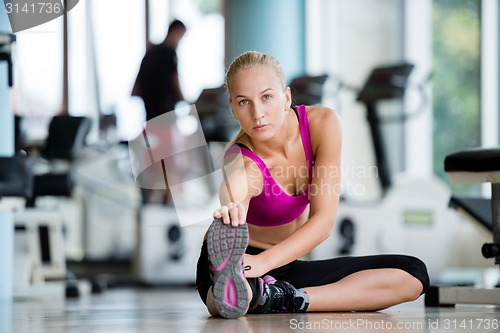 Image of trainer with clipboard standing in a bright gym