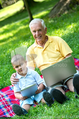 Image of grandfather and child using laptop