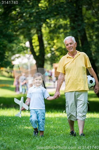 Image of grandfather and child have fun  in park