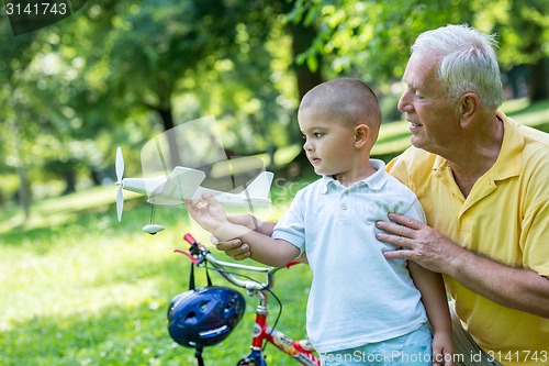 Image of grandfather and child have fun  in park