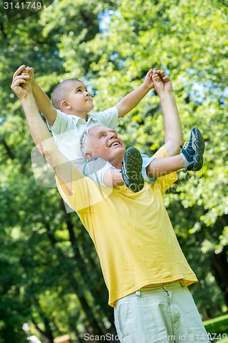 Image of grandfather and child have fun  in park