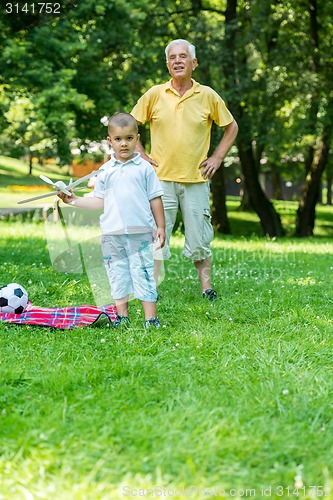 Image of grandfather and child have fun  in park