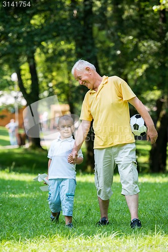 Image of grandfather and child have fun  in park