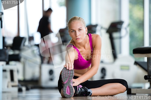 Image of woman stretching and warming up for her training at a gym