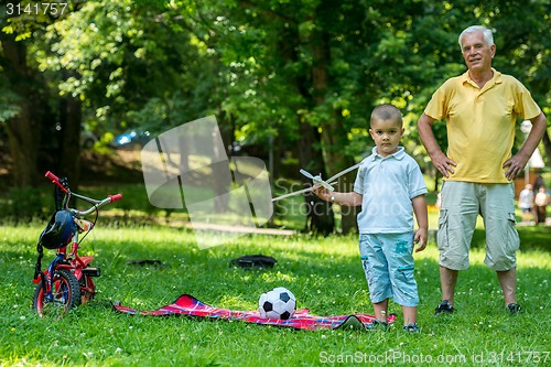 Image of grandfather and child have fun  in park
